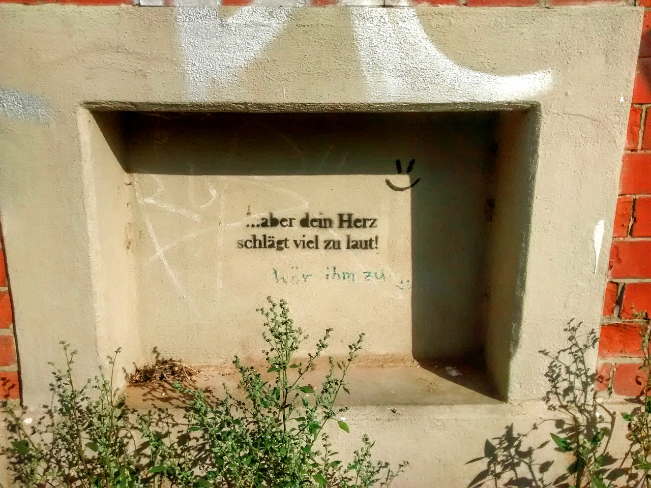 Ein Text, geschrieben auf einem zugemauerten Fenster